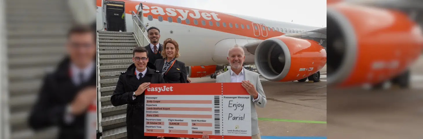 Image of some easyJet employees holding a large boarding pass for Paris