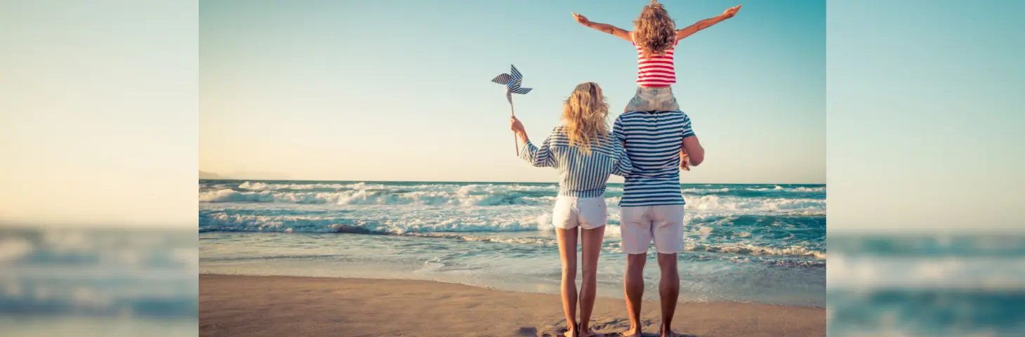 Image of a mother and father with their child on the beach